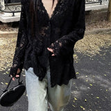 Person wearing a black lace top and light-colored pants outdoors.