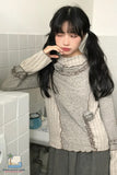 Person wearing a textured sweater with ruffled details in a bathroom setting