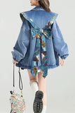 Person wearing a blue denim jacket with floral patterns on a plain background