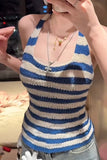 Person wearing a blue and white striped tank top with layered necklaces.