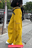 Person wearing yellow cargo pants on a sidewalk with a blurred background