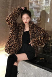 Person wearing a leopard print coat in an indoor setting