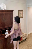 Woman standing in a room with wooden cabinet and floral painting on the wall