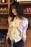 Person wearing a floral cardigan in a bar setting