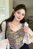 Woman wearing a floral top and white blouse indoors