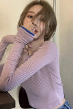 Person wearing a striped long-sleeve top with a neutral background