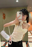 Woman taking a mirror selfie wearing a white top and black pants, holding a phone.