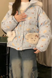 Person wearing a light blue puffer jacket with animal patterns and fluffy cuffs indoors.