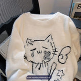 White sweater with black cat design on a chair