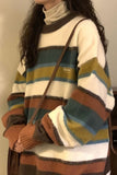 Person wearing a multicolored striped sweater with a plain background