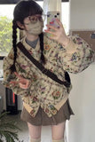 Person wearing a floral jacket and plaid skirt, taking a mirror selfie.