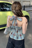Woman wearing a plaid top with a bow detail, standing in front of a lime green car.