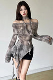 A woman modeling a sheer, long-sleeve, off-the-shoulder top with a gray and brown tie-dye pattern, paired with a high-neck choker and black shorts.
