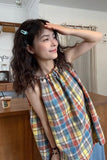 Woman wearing a colorful plaid dress in an indoor setting