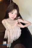 Woman wearing a light pink lace dress sitting on a wooden floor.