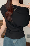 A woman wearing a black off-the-shoulder short-sleeve top paired with blue jeans, shown from the neck down in an indoor setting.