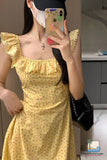 Woman taking a mirror selfie wearing a yellow floral dress.