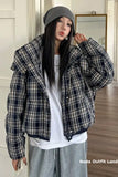 Person wearing a plaid jacket and gray beanie indoors