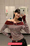 Woman taking a mirror selfie wearing a striped shirt in a bathroom.