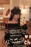 Woman taking a mirror selfie wearing a black and white patterned sweater and cap indoors.