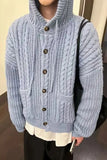 Person wearing a blue knitted cardigan with buttons indoors
