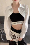 Person wearing a white shirt over a black sports bra and skirt with visible branding.