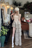 Woman in a stylish outfit standing in an elegant room with decor elements.