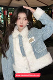 Person wearing a blue denim jacket with white fur lining indoors