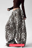 Leopard print harem pants worn by a person on a white background with a visible brand name.