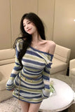 Woman wearing a striped dress sitting on a couch in a living room.