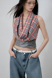 Person wearing a plaid top and jeans on a plain background