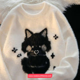 White sweater with a black cat design and paw prints on a fluffy background