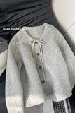 Gray cardigan with buttons on a laptop and chair background