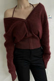 Maroon off-shoulder sweater worn by a person against a white wall.