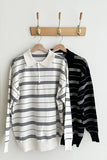 Two striped shirts hanging on a wooden rack against a white wall.