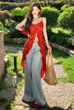 Woman in a red top and light blue jeans standing in a garden