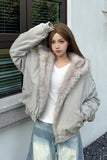 Woman wearing a light gray bomber jacket with fur trim outdoors.