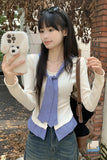 Woman taking a selfie with a phone case featuring a dog design, wearing a blue checkered scarf and white shirt.