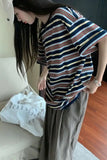 Person wearing a striped shirt and long pants in an indoor setting