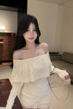 Woman in a white off-shoulder outfit standing in a room with furniture.