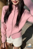 Person wearing a pink sweater and white shorts outdoors