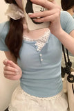 Person wearing a light blue top with white lace details, holding a phone with a cartoon case.