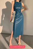 Woman wearing a blue dress holding a clutch against a neutral background