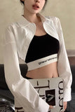 Person wearing a black sports bra with a visible brand logo, holding a magazine.