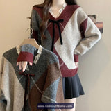 Patterned sweater with a bow tie on a hanger against a neutral background