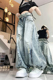 Person wearing oversized light blue jeans and white sneakers in a modern indoor setting.