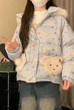 Person wearing a light blue jacket with animal patterns and fur trim indoors.