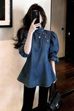 Woman wearing a blue denim dress with a blurred background