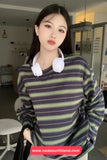 Person wearing a striped sweater with headphones around their neck in an indoor setting.