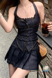 Person wearing a denim dress holding a drink outdoors.